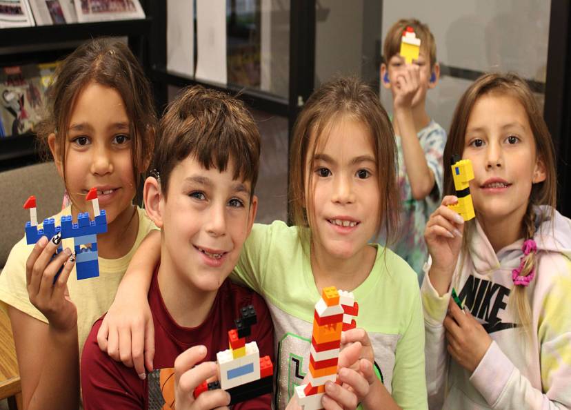 Students showing off their creations using legos