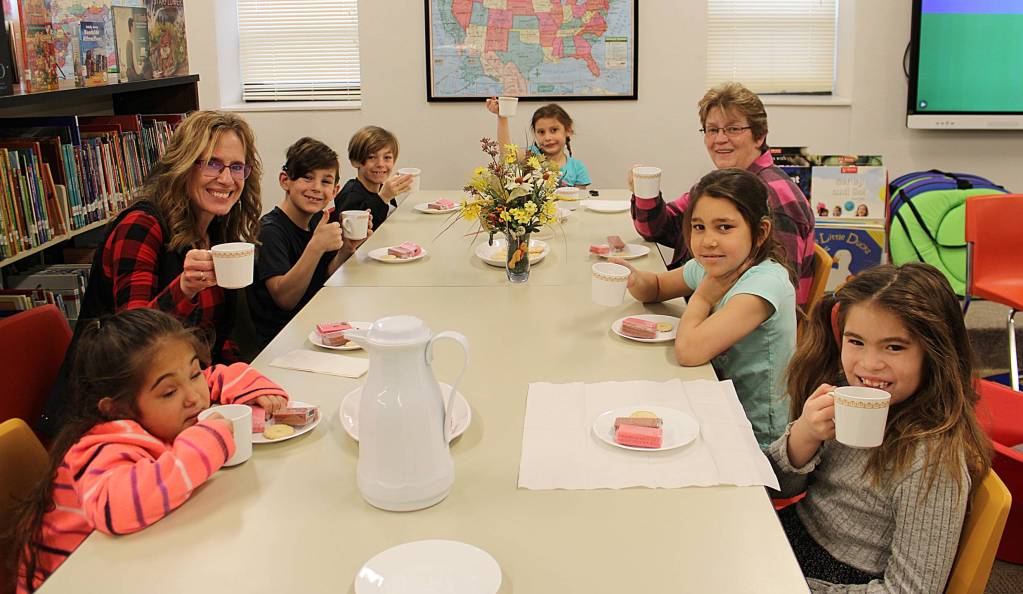 Elementary students having a tea party in the library after reading a book about it
