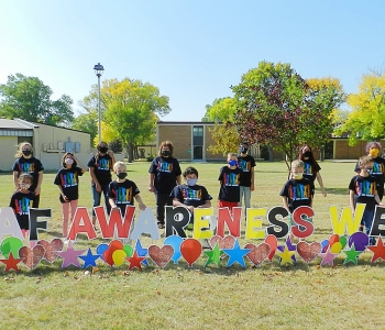 Students behind Deaf Awareness Week yard lettering